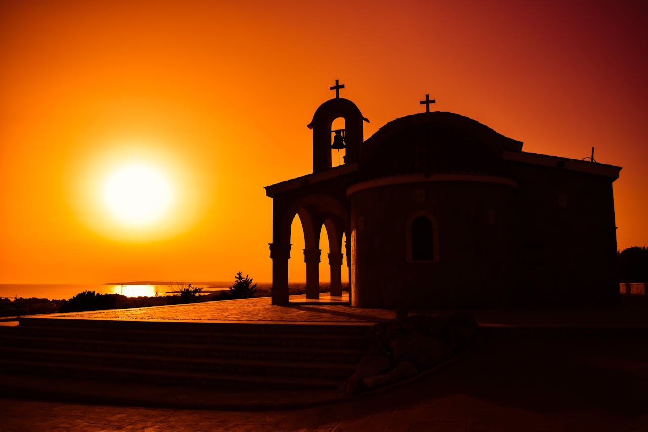 Stunning silhouette of a church against a vibrant sunset sky, rich in warm hues.