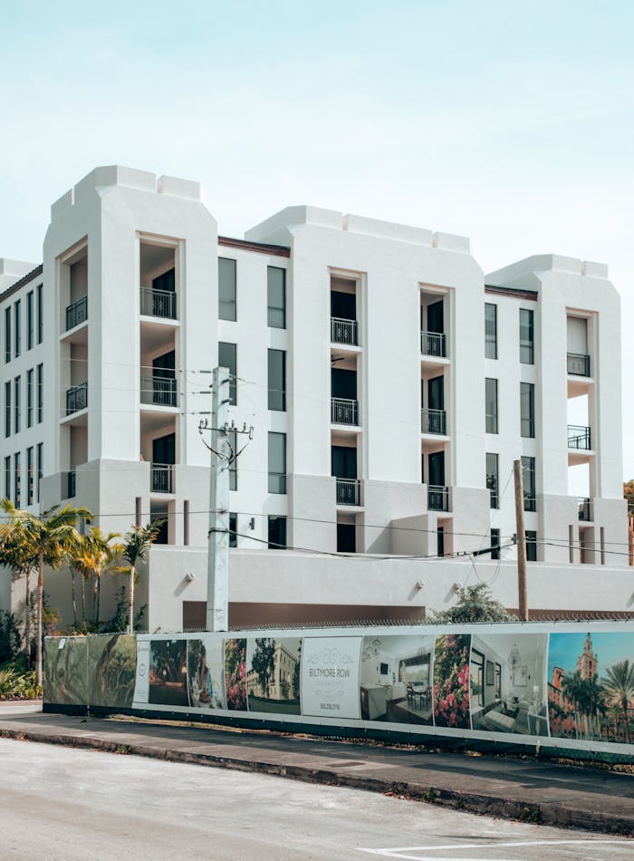 Elegant modern apartment building exterior in Coral Gables, Florida, under a clear blue sky.